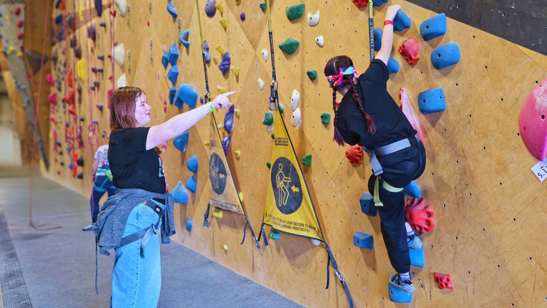 Coach guiding a climber on the wall